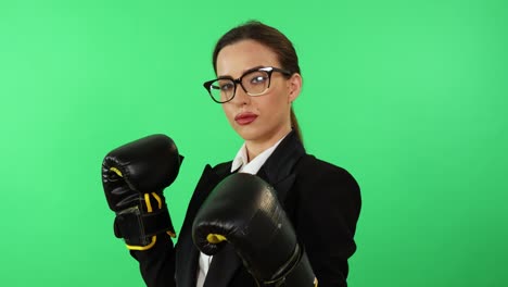 Young-businesswoman-in-glasses-and-formal-dress-wears-boxing-gloves-to-combat-work-stress