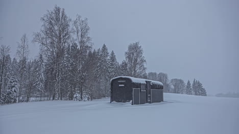 Small-cabin-in-snow-storm-in-remote-landscape,-Timelapse