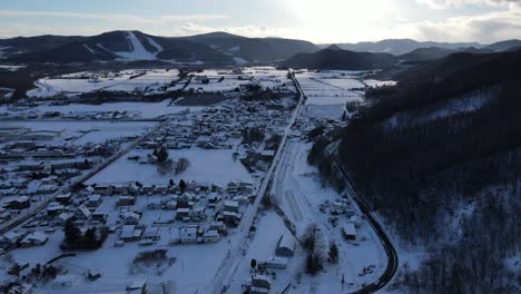 Schneebedeckte-Stadt-Und-Dorf-Im-Bergtal.-Drohnen-Pullback-Ansicht