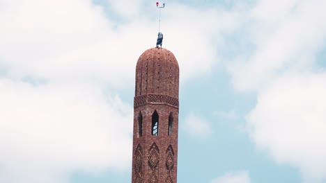 Pan-up-for-the-scale-of-the-minaret-silo-while-a-worker-on-the-top-trying-to-finish-it