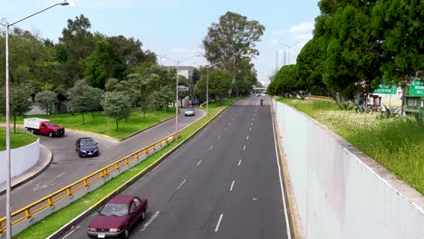 Time-lapse-of-Churubusco-Avenue-in-Mexico-City,-showing-a-large-building-in-the-background