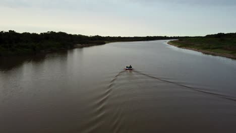 Impresionante-Toma-De-Adelantamiento-De-Un-Pescador-Navegando-En-Aguas-Tranquilas,-Río-Tebicuary,-Paraguay