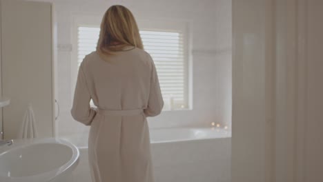 Beautiful-woman-walking-towards-filled-bathtub-and-opening-her-robe