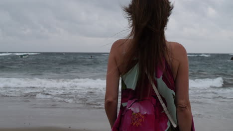 Cinematic-shot-at-dawn-of-a-woman-admiring-the-ocean-waves-at-Las-Canteras-beach