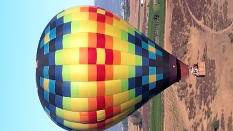 Aerial-View-Of-Multi-Coloured-Hot-Air-Balloon-Flying-Above-Temecula