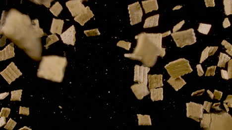 Stop-motion-of-crackers-on-a-black-background-exploding-and-flying-in-the-air---extreme-slow-motion-top-shot