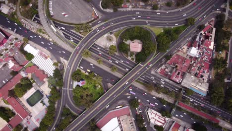 Aerial-turning-view-of-a-cross-avenue-with-little-garden-in-the-middle,-Taxqueña,-Mexico-City