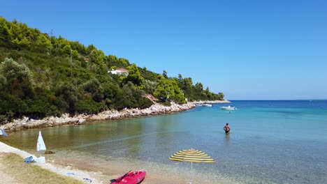 Schwenk-über-Einen-Atemberaubenden-Strand-Und-Eine-Person,-Die-Im-Meer-Bei-Naxos,-Griechenland,-Spazieren-Geht