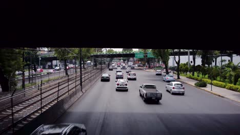 Mexican-avenue-view-with-a-drone-following-cars-under-a-bridge