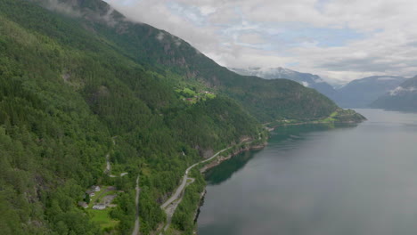 Aerial-view-of-scenic-road-hugging-the-impressive-Hardanger-Fjord,-Norway