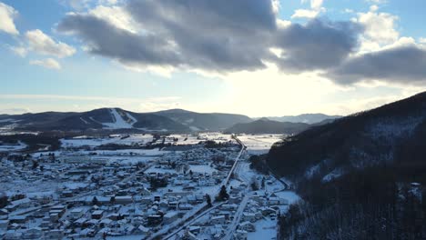 Schöne-Luftaufnahme-Der-Schneebedeckten-Stadt-Und-Der-Berge-In-Japan