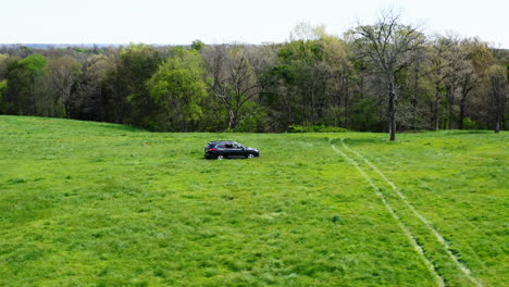 Land-Surveyors-In-A-Black-SUV-Car-Driving-On-The-Farm-At-Daytime