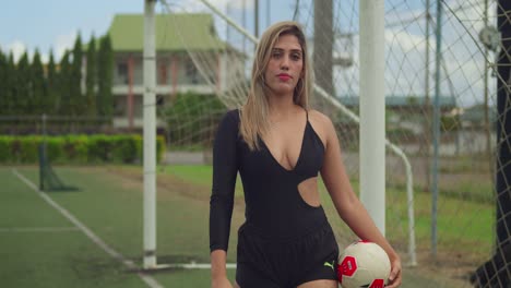 Sexy-blonde-latina-walking-at-a-football-stadium-while-holding-a-ball-in-her-hand