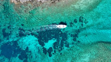 Blue-Lagoon-turquoise-waters-sailing-A-small-boat-is-sailing-in-the-cristal-clear-waters-of-the-Adriatic-Sea-in-the-region-of-Blue-Lagoon-near-Krknjaš-Veli-Island