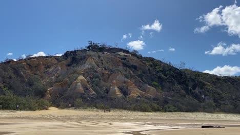 The-Pinnacles---a-dramatic-and-vividly-colored-sandstone-formation-is-deep-reds,-oranged-and-yellow-north-of-Cathedral-Beach-on-iconic-K'gari-in-Queensland