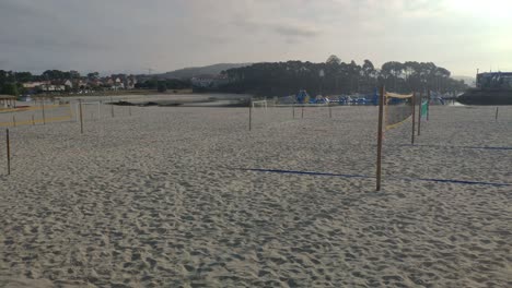 Strandbereich-Mit-Fußballfeld-Im-Sand-Und-Volleyball-Ohne-Menschen-An-Einem-Bewölkten-Morgen-Im-Frühsommer,-Rollschuss-Nach-Rechts
