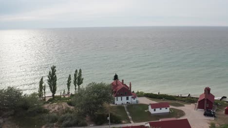 Historic-Point-Betsie-Lighthouse-in-Frankfort,-Michigan-located-along-Lake-Michigan-with-drone-video-from-behind-moving-forward