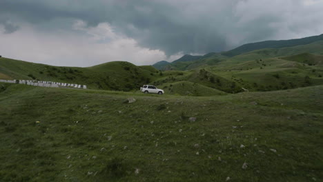 Drone-Flying-Towards-SUV-Car-Parked-On-Rural-Road-With-Overcast-Near-Aspindza-In-Georgia
