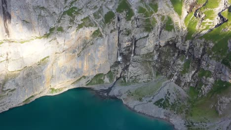 Vista-Aérea-Detallada-De-La-Montaña-Blümisalp-Y-El-Lago-Oeschinen,-Cerca-De-La-Formación-Geológica-Rocosa-Alpes-Suizos