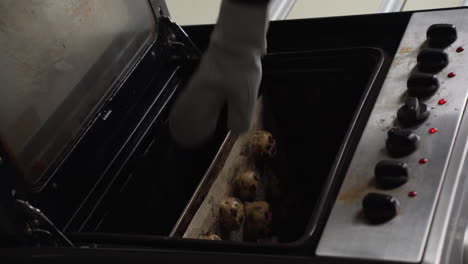 Vertical-Shot-Of-A-Pastry-Chef-Placing-Cookies-Inside-Pre-heated-Oven-For-Baking