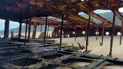 Interior-of-the-Maheno---the-rusted-hulk-of-a-old-shipwreck-washed-up-on-the-beach-of-Fraser-Island-K'gari-and-bureid-deep-in-the-sand,-decaying-away-to-dust