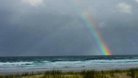 Storm-over-the-Pacific---a-vivid-and-dramatic-rainbow-cuts-across-the-sky-of-the-stormy-and-threatening-ocean-scene