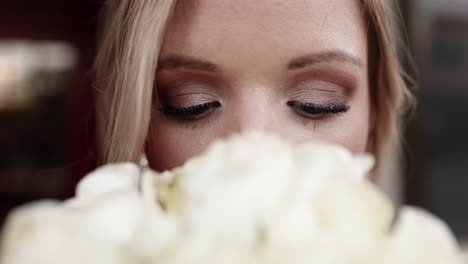 Close-up-shot-of-the-bride’s-eyes-with-her-white-rose-bouquet-in-the-foreground