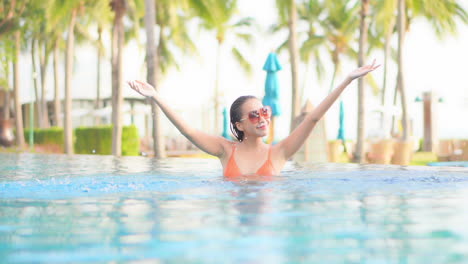 Eine-Hübsche-Frau-Spielt-Im-Wasser-Eines-Resort-Swimmingpools