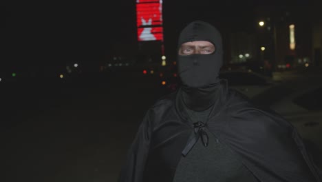 Caucasian-Man-In-Full-Black-Cape-And-Hood-Mask-Costume-At-Night-In-Bahrain