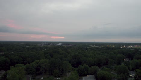 Aerial-tilt-up-shot-over-large-woodworking-factory-during-evening-time-surrounded-by-trees