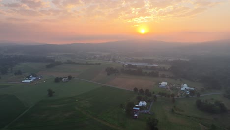 An-aerial-sunrise-over-the-foggy-rural-countryside-in-Lancaster-County,-Pennsylvania