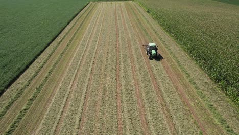 On-a-farm-field-in-southwest-Wisconsin,-a-farmer-rakes-hay-using-a-rotary-hay-rake-5