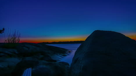 Backwards-hyper-lapse-at-sunset-of-the-water-moving-in-rocky-lakeshore
