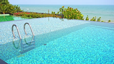 An-empty-resort-swimming-pool-overlooks-the-ocean-horizon