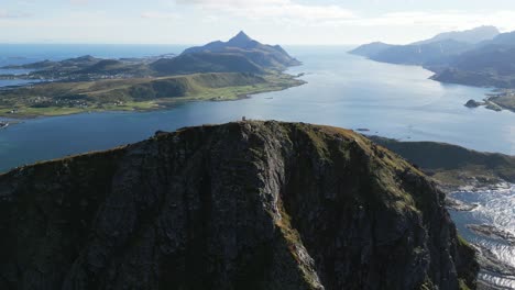Flying-over-Offersoykammen-mountain-plateau-in-Lofoten,-Norway-with-scenic-views-across-the-mountains,-oceans,-fjords,-lakes-and-sea