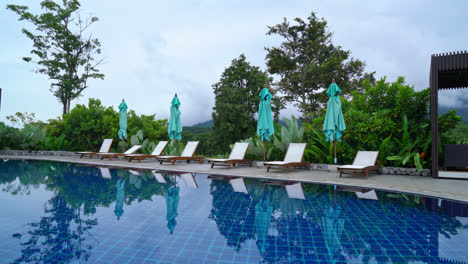 Bed-pool-around-swimming-pool-with-mountain-hill-background