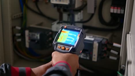 Técnico-Asiático-Utiliza-Un-Dispositivo-Térmico-Para-Comprobar-La-Temperatura-Del-Cable-Eléctrico-1