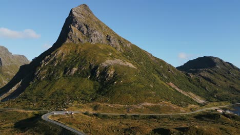 Fliegen-Sie-Von-Fredvang-Lofoten-Norwegen-über-Die-Berühmte-Brücke,-Die-Den-Ozean-überquert,-In-Richtung-Des-Grasbedeckten-Berges