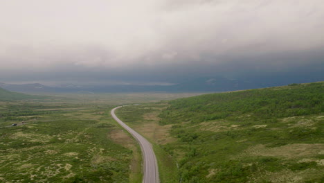 Highway-cuts-through-lush-green-Dovrefjell-mountain-area