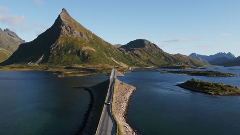 Autoverfolgungsjagd-über-Die-Fredvang-Lofoten-Braut-In-Norwegen-Mit-Blick-Auf-Den-Ikonischen-Berg-Am-Ende-Der-Schmalen-Brücke,-Die-über-Den-Ozean-Führt