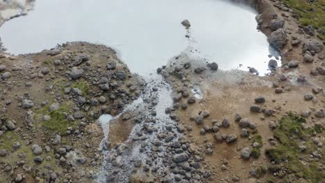 Aerial-flyover-mud-pool-with-rising-steam-in-Iceland-during-sunny-day---Expedition-of-Iceland-Island-in-summer