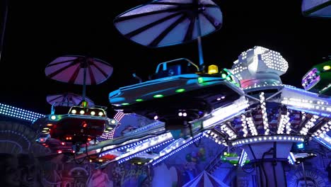 Flying-saucers-carousel-at-night-in-a-city-amusement-park