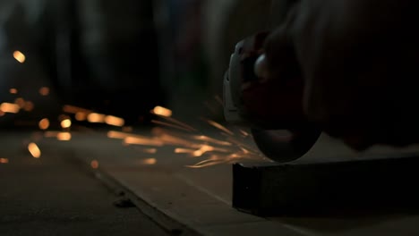 Hand-of-an-afro-american-blacksmith-worker-using-an-angle-grinder,-close-up-of-metal-working-concept