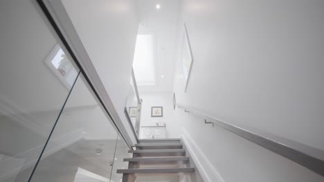 Going-upstairs-through-a-see-through-glass-stair-wall-in-a-tilt-cemara-angle-to-show-the-flat-roof-window-at-the-second-floor-ceiling-in-a-house