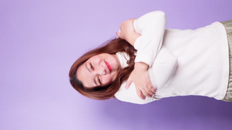 Vertical-Young-beautiful-woman-feeling-in-love,-smiling,-cuddling-and-hugging-herself-being-selfish-on-purple-background-1