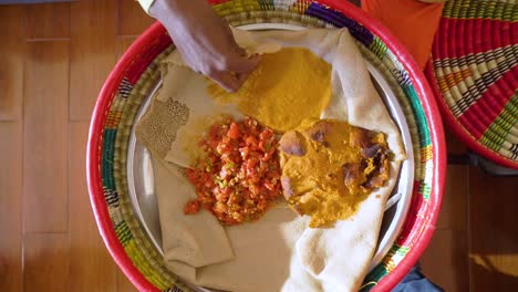 A-traditional-Ethiopian-injera-bread-in-a-mesob-with-stew,-Ethiopia