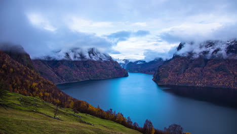 Cloudscape-on-the-cliffs-overlooking-a-deep-fjord-with-sheep-on-the-hillside-in-autumn---time-lapse