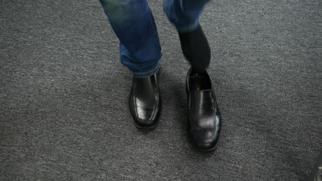 A-man-putting-on-his-shoes-on-the-carpet