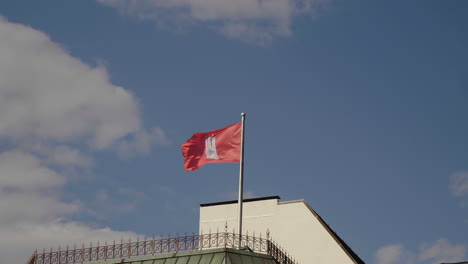 Flagge-Der-Stadt-Hamburg-Weht-Im-Wind-Mit-Blauem-Himmel-Und-Wolken-Auf-Der-Rückseite-Des-Gebäudes