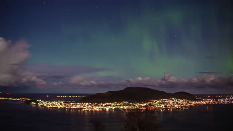 Tiro-De-ángulo-Alto-De-La-Ciudad-A-Lo-Largo-De-La-Isla-De-Alesund,-Noruega-Con-La-Vista-De-La-Aurora-Boreal-En-Timelapse,-Visible-En-La-Noche